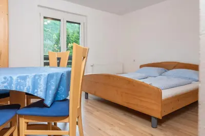 a bedroom with a bed and a table and chairs at Apartments Žnidar in Bohinj