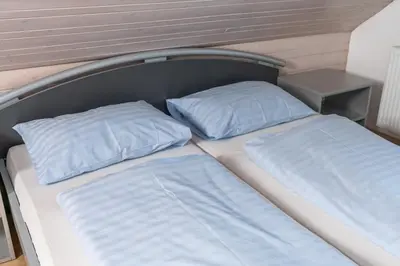 a bed with two pillows on top of it at Apartments Žnidar in Bohinj
