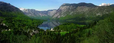 a lake in the middle of a valley with mountains at Apartments Žnidar in Bohinj
