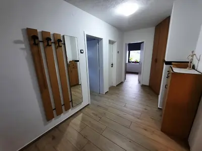 an empty room with a hallway with doors and wood floors at Apartment Break in Rob
