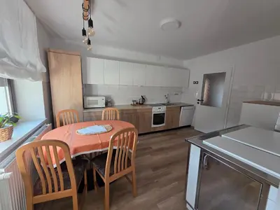 a kitchen with a table and chairs in a kitchen at Apartment Break in Rob