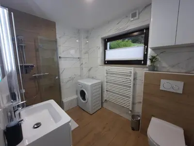 a bathroom with a sink and a toilet and a window at Apartment Break in Rob