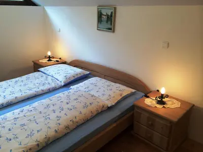 a bedroom with two beds and two candles on tables at Apartments Pod macesnovo streho in Solčava