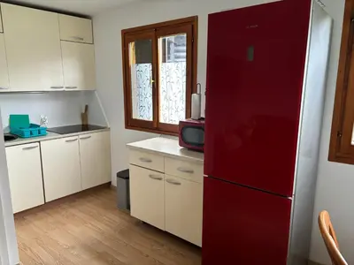 a kitchen with a red refrigerator and white cabinets at Green Sky House in Mostec