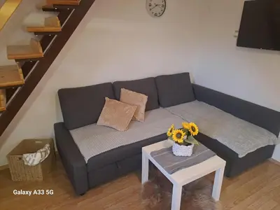 a living room with a couch and a table with flowers at Green Sky House in Mostec