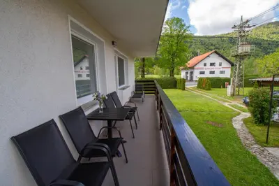 a balcony with chairs and a table and a yard at Apartma pri Klari in Kočevje