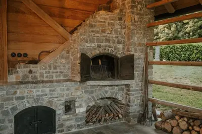 a stone fireplace in a room with a window at Sweet Retreat in Trebelno