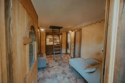 a living room with a blue couch and a kitchen at Sweet Retreat in Trebelno