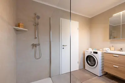 a bathroom with a shower and a washing machine at Apartma Jana in Žirovnica