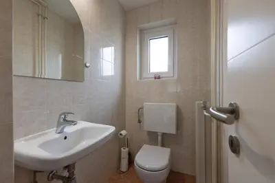 a bathroom with a sink and a toilet and a window at Apartma Jana in Žirovnica