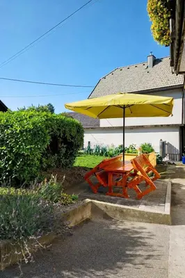 a wooden picnic table with a yellow umbrella at Apartma Jana in Žirovnica