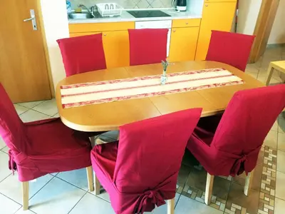 a wooden table with red chairs and a cake on it at Apartments Bogdanovic in Maribor