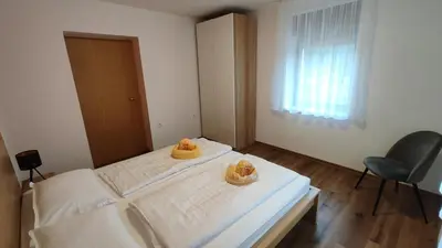 a bedroom with a bed and a chair and a window at Apartment Irena Bovec in Bovec