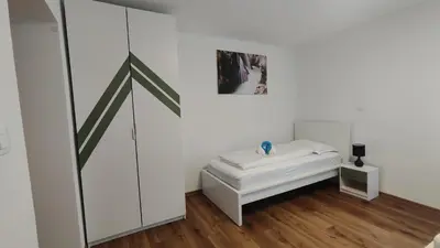 a white room with a bed and a picture on the wall at Apartment Irena Bovec in Bovec
