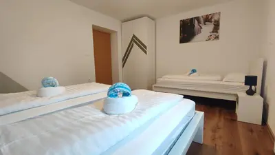 two beds in a room with white walls at Apartment Irena Bovec in Bovec