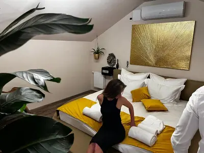 a woman in a black dress standing on a bed at JUNGLE Wellness Apartment in Trzin