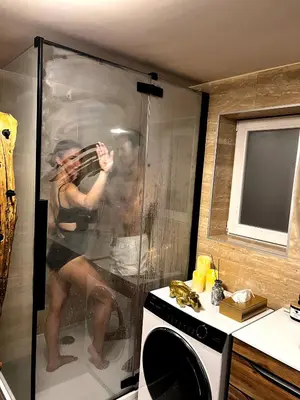 a woman playing a violin in a shower in a bathroom at JUNGLE Wellness Apartment in Trzin