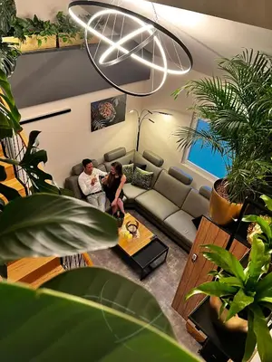 a man and a woman sitting in a living room at JUNGLE Wellness Apartment in Trzin