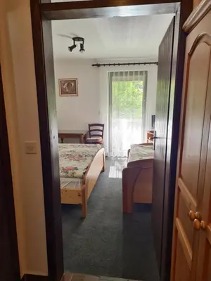 a room with a bedroom with two beds and a window at Gostilna Batišt in Bohinjska Bela