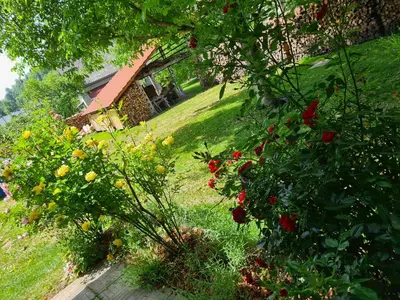 a view of a garden with flowers and a house at Gostilna Batišt in Bohinjska Bela