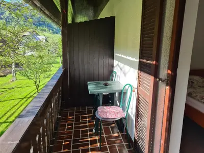 a small table and a chair on a balcony at Gostilna Batišt in Bohinjska Bela