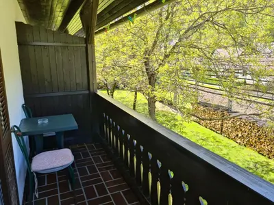 a porch with a bench and a table and trees at Gostilna Batišt in Bohinjska Bela