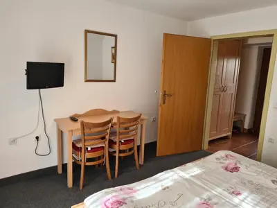 a room with a table and chairs and a bed at Gostilna Batišt in Bohinjska Bela