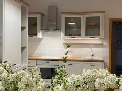 a kitchen with white cabinets and white flowers at Apartma ROGATEC in Rogatec