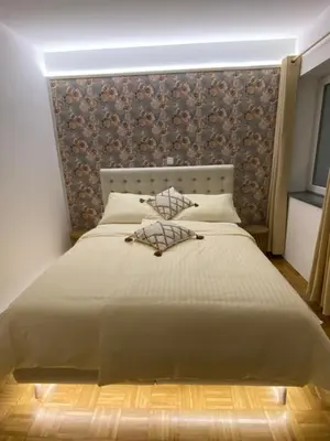 a bedroom with a large white bed with a wall at Apartma ROGATEC in Rogatec