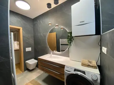 a bathroom with a sink and a washing machine at Apartma ROGATEC in Rogatec
