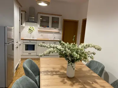 a vase of flowers on a wooden table in a kitchen at Apartma ROGATEC in Rogatec