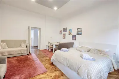 a bedroom with a bed and a couch and a table at Nick & Klaras Central Apartments in Ljubljana
