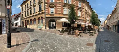 a brick building with tables and chairs on a street at Nick & Klaras Central Apartments in Ljubljana
