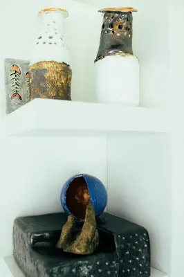 two shelves with two vases on top of a table at ArtRock Studio in Radovljica