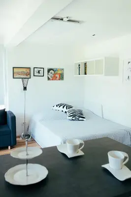 a bedroom with a bed and two white tables at ArtRock Studio in Radovljica