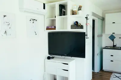 a living room with a tv on a white wall at ArtRock Studio in Radovljica