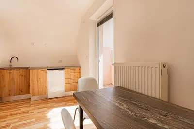 a kitchen with a table and chairs in a room at Apartments Lavrič in Velike Bloke