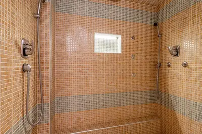 a bathroom with a shower with a tub and a window at Apartments Lavrič in Velike Bloke