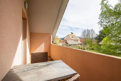 a balcony with a table and a view of a house at Apartments Lavrič in Velike Bloke