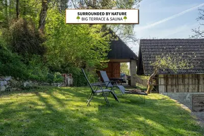 a yard with two chairs and a house at Hiška Gmajna in Slovenj Gradec
