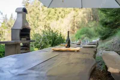 a bottle of wine sitting on top of a wooden table at Hiška Gmajna in Slovenj Gradec