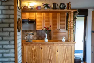 a kitchen with a wooden cabinet with vases on it at Hiška Gmajna in Slovenj Gradec