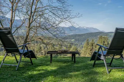 two chairs and a table in the grass at Hiška Gmajna in Slovenj Gradec