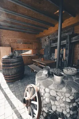 a room with a wooden building with a wooden wheel at KAJZA KOLOVRAT in Mozirje