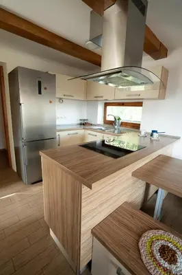 a kitchen with a stainless steel refrigerator and a counter at KAJZA KOLOVRAT in Mozirje