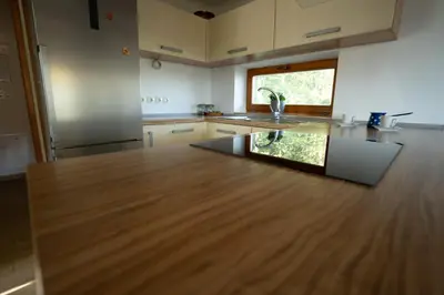 a kitchen with a large wooden counter top at KAJZA KOLOVRAT in Mozirje