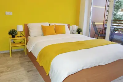 a bedroom with a large bed with a yellow wall at Apartment Marusa in Moravske Toplice