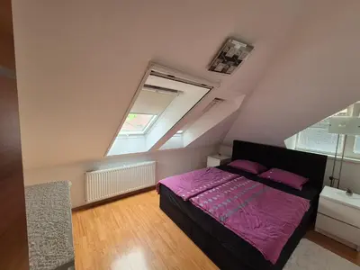 a bedroom with a purple bed in a attic at Oddih v mirnem in zelenem okolju in Škofljica