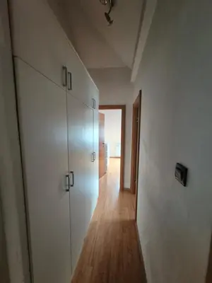 a hallway with white cabinets and a wooden floor at Oddih v mirnem in zelenem okolju in Škofljica