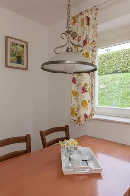 a chandelier hanging over a table with a tray of dishes at Cozy Garden Flat in Ljubljana